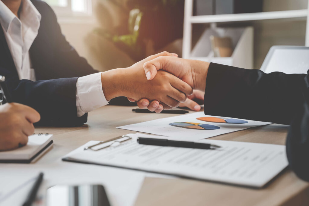 Image of two people shaking hands over a contract to augment the article which speaks to rent to buy South Africa